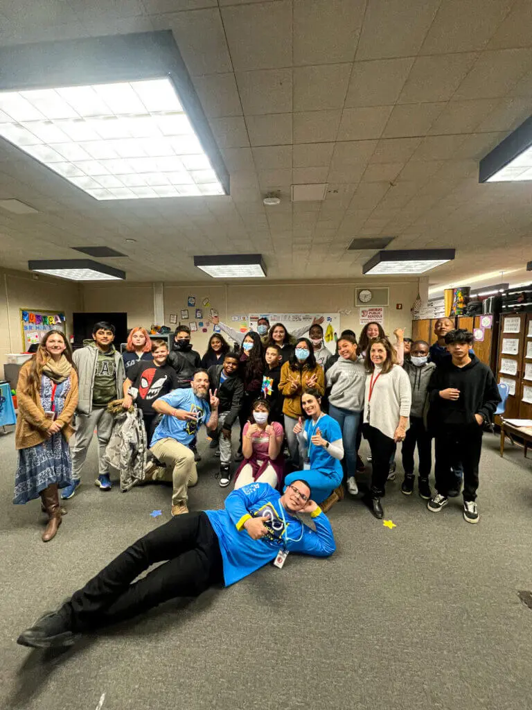 Smiling student wearing yellow glasses in a school library